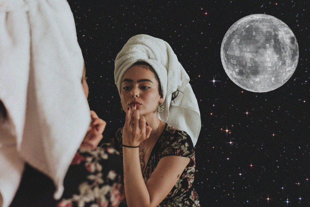 Woman staring in reflection with disco moon behind her